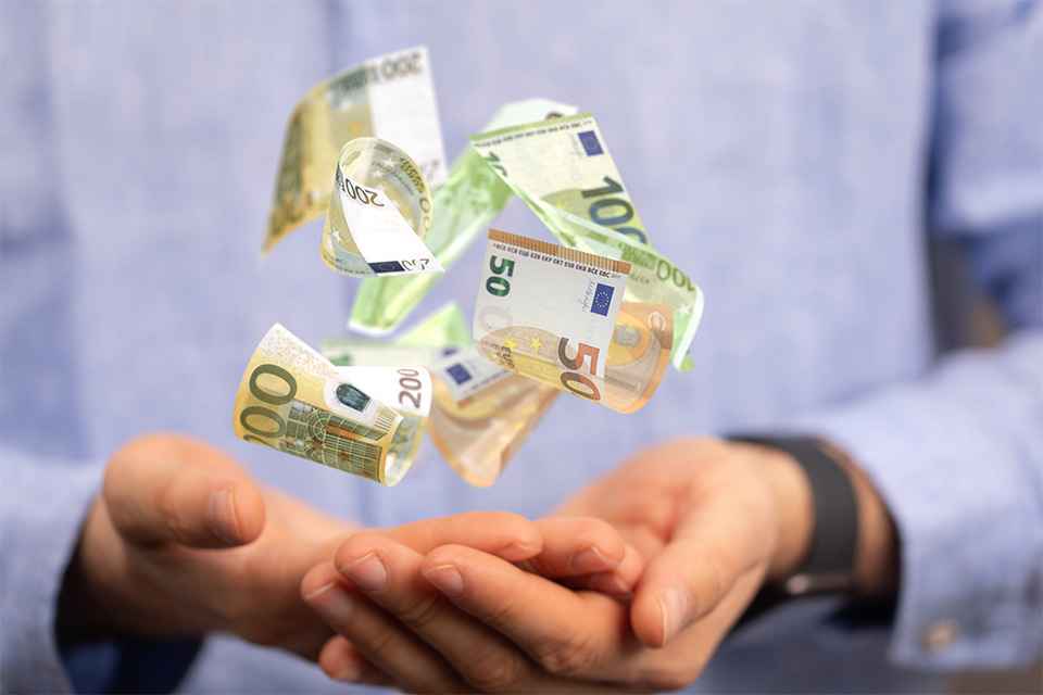 Hand mit schwebenden Geldscheinen